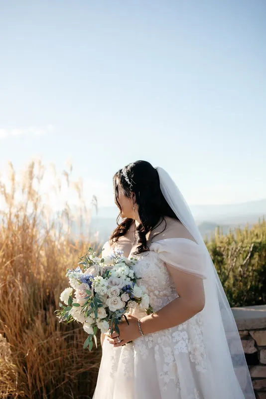 Bride with her bouquet in the hills